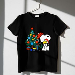 Snoopy and Woodstock Celebrating Christmas by the Tree 1 T Shirt 1.jpg